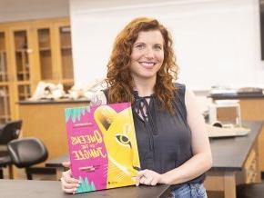 Carly York displays the cover of her book Queens of the Jungle